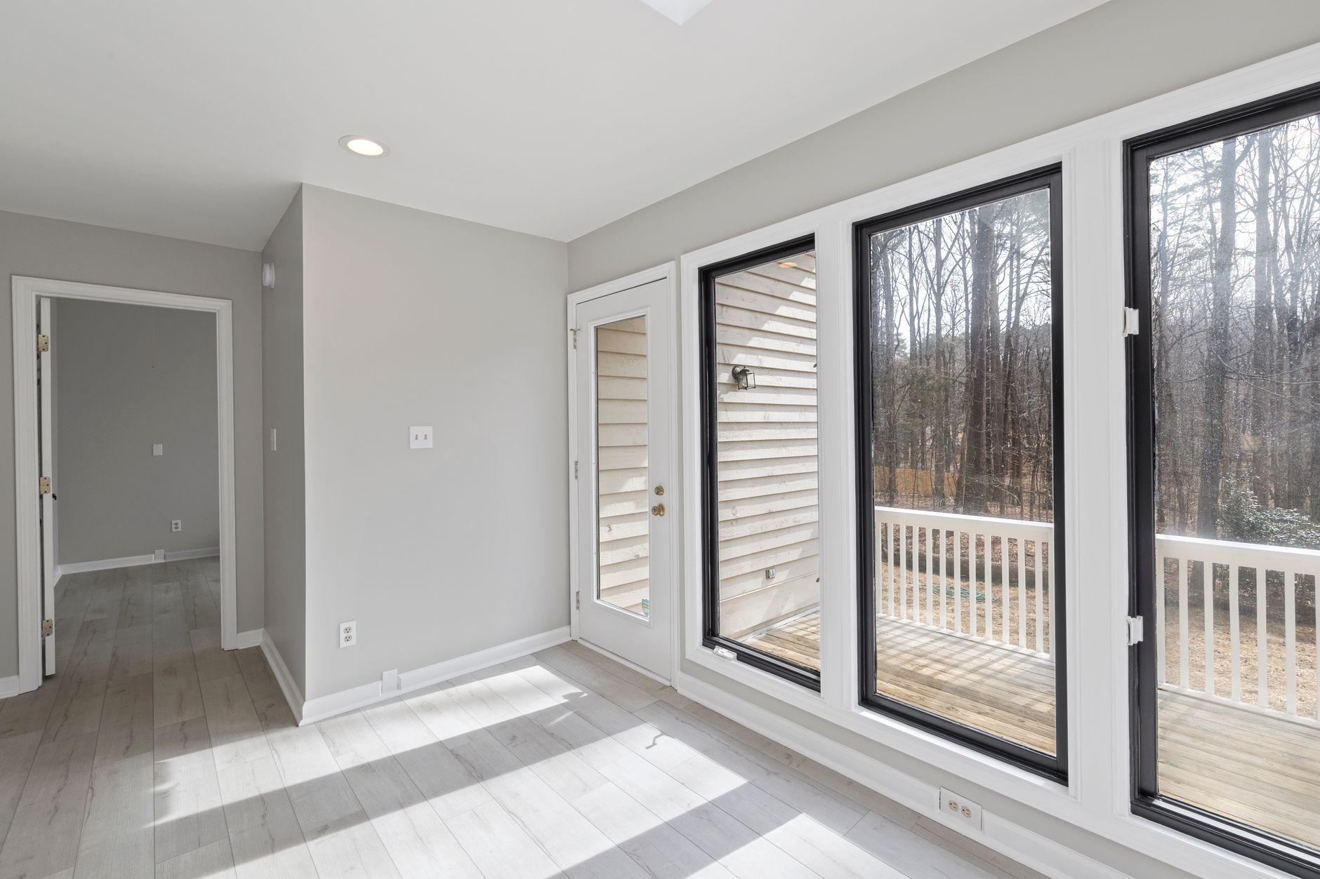 Spacious and bright room with large glass windows overlooking a serene outdoor setting